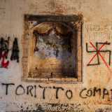 Tra gli antichi simboli si distingue solo una corona regale da cui cadono due tendaggi rossi, il tutto dominato da un decoro vegetale a otto petali sull�arcata
